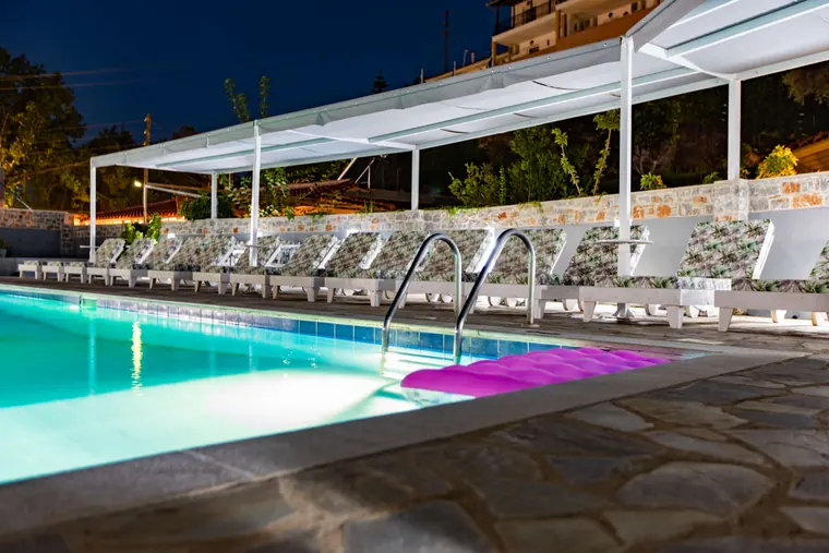 The pool and sunbeds lit up at night