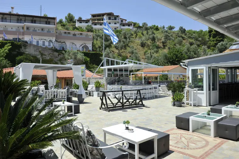 The terrace, the Greek flag and the green hills