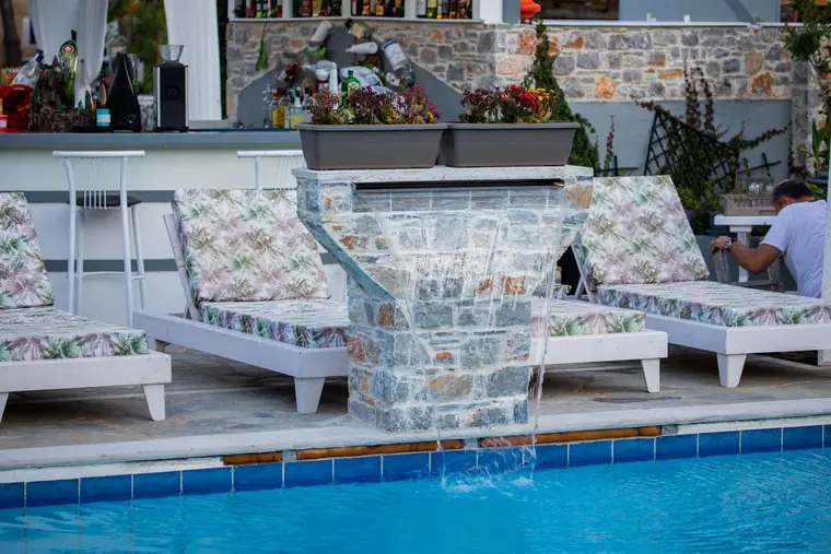Sunbeds beside the pool's waterfall wall